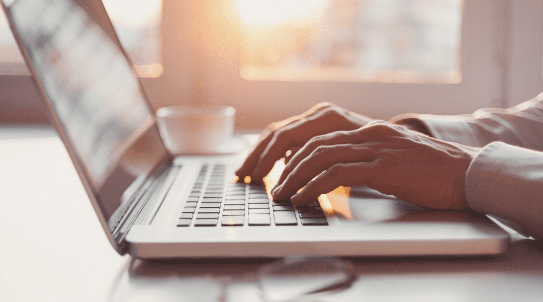 hands typing on a laptop