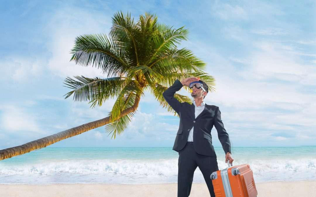 businessman holding suitcase on beach