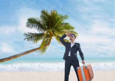 businessman holding suitcase on beach