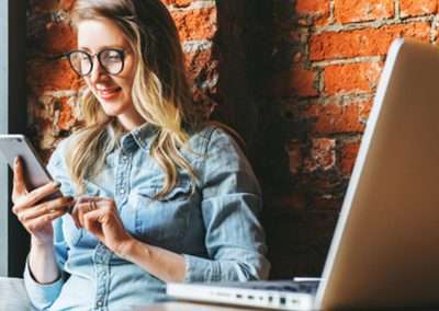 working sitting in front of brick wall using phone