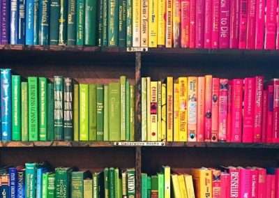 rainbow colored books on shelves