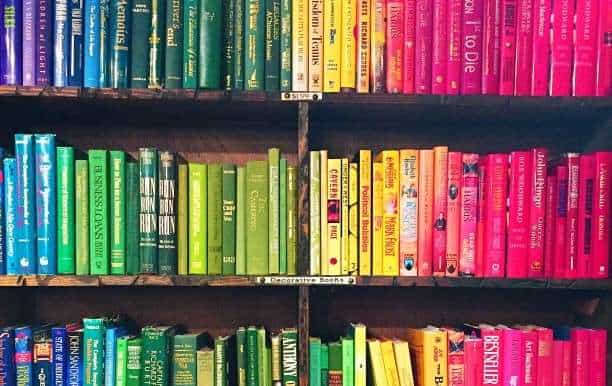 rainbow colored books on shelves