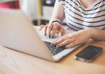 girl with green nails typing on keyboard