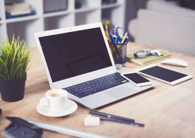 laptop on a desk with a plant