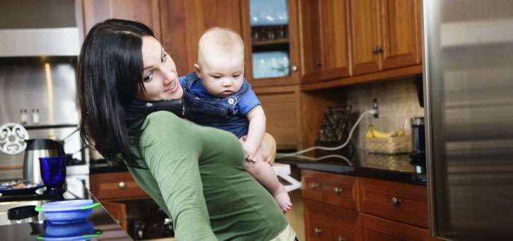 mom in the kitchen holding a baby