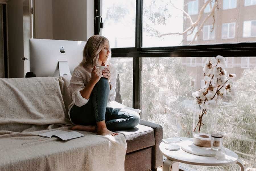 woman sitting on couch having coffee