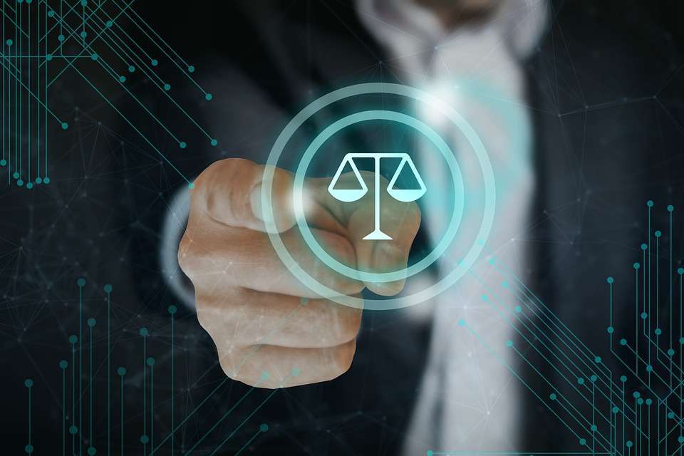 man pointing at scales of justice icon