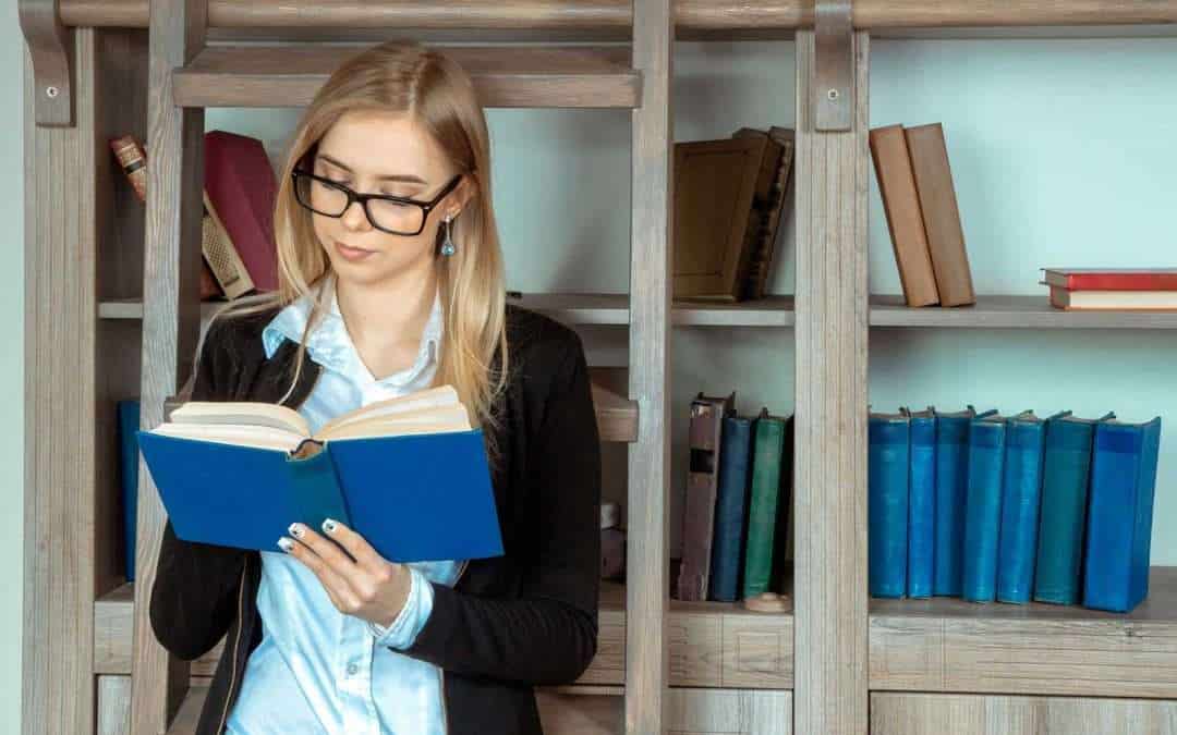 woman reading in front of shelves