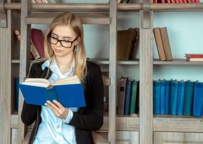 woman reading in front of shelves