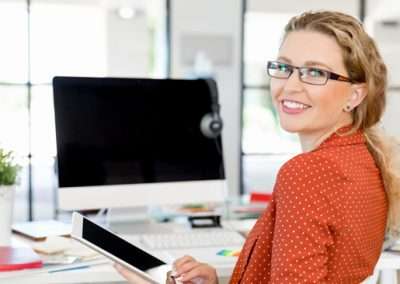 woman in orange shirt at computer