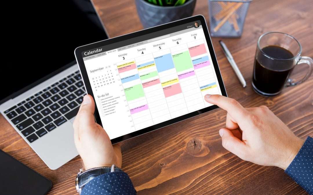 Man using calendar app on tablet in office