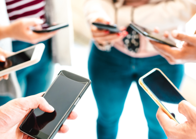 A group of people looking down at their cell phones.