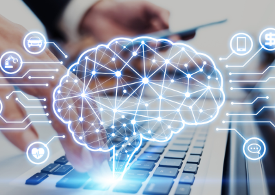 Men’s hands typing on a laptop keyboard, with a brain icon and various business icons floating around it in the background.