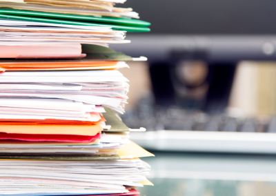 Closeup of a large stack of manila files and folders.