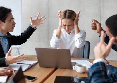 People in a meeting are gesturing and looking tense.