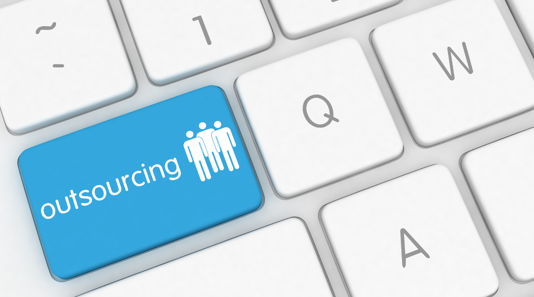 a bright blue button with the words outsourcing and person icons on white keyboard.