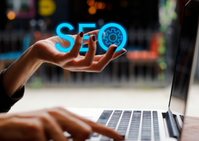 person at a laptop keyword. One hand is holding the letters SEO in its palm.