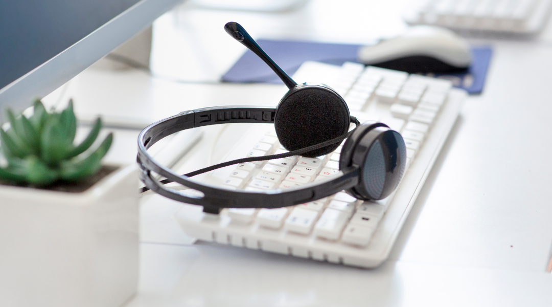 A headset sitting on a computer keyboard.