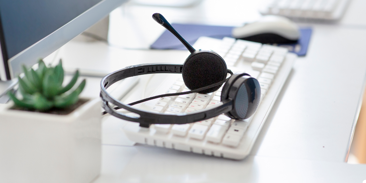 A headset sitting on a computer keyboard.