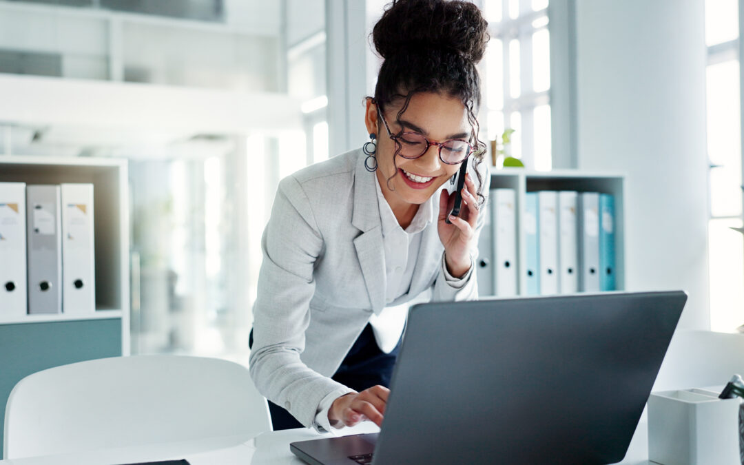 Happy corporate woman working in law office on cellphone.
