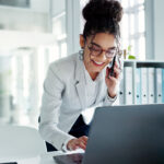 Happy corporate woman working in law office on cellphone.