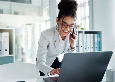 Happy corporate woman working in law office on cellphone.