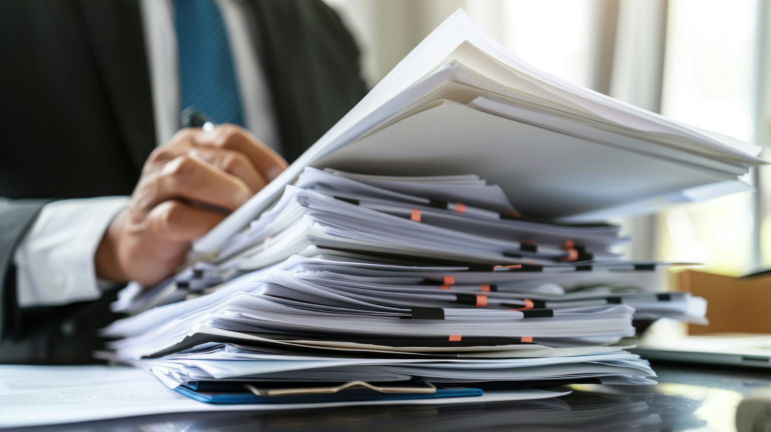 A lawyer reviewing a stack of legal documents in an office setting