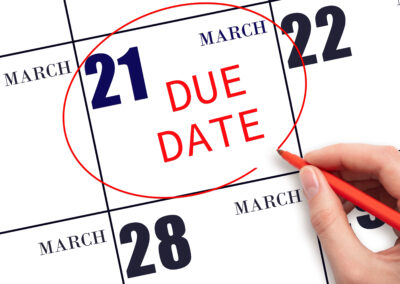 Writing text DUE DATE on calendar date March 21 and circling it.