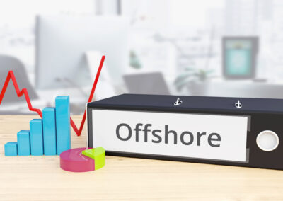 Folder on desk with offshore label beside finance diagrams.