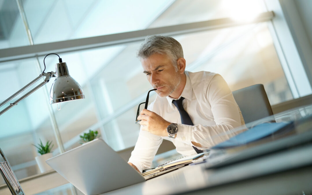 Bankruptcy attorney working on laptop in office, being concerned 