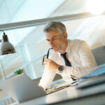 Bankruptcy attorney working on laptop in office, being concerned 
