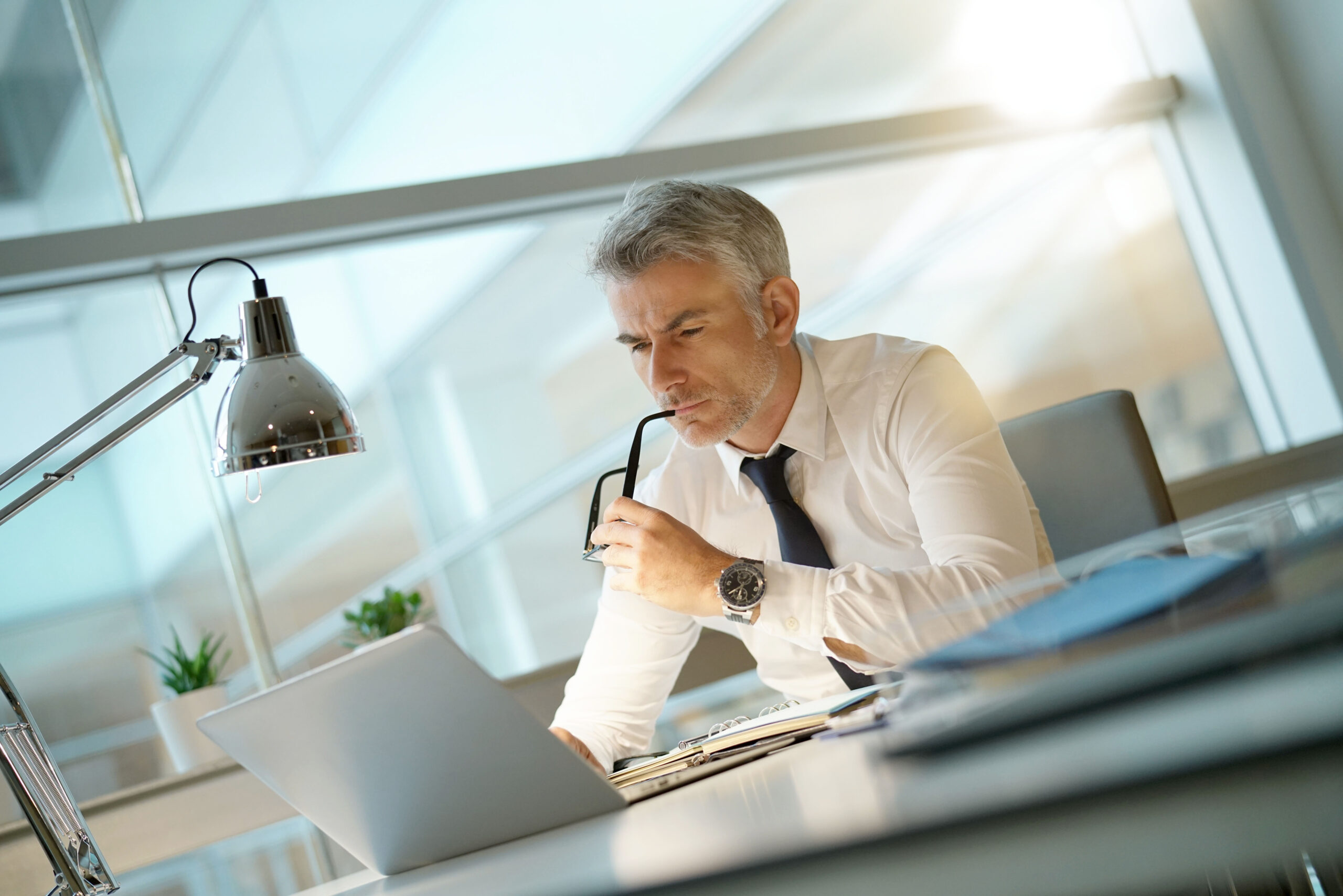 Bankruptcy attorney working on laptop in office, being concerned 