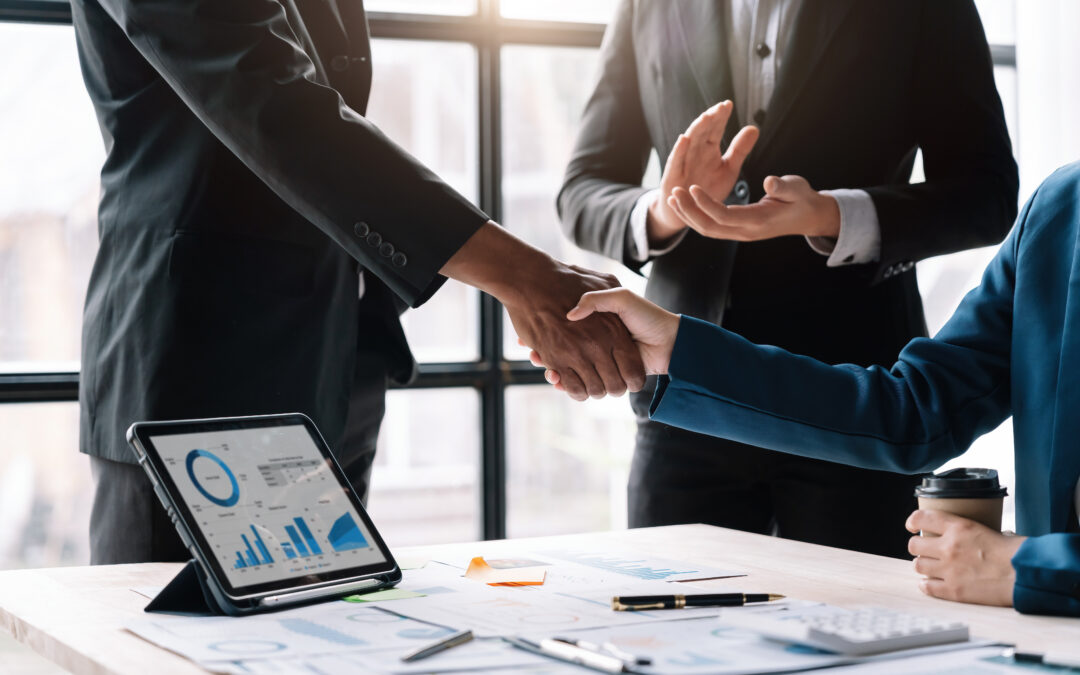 Corporate professionals shaking hands to finalize a business transaction or merger.
