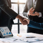 Corporate professionals shaking hands to finalize a business transaction or merger.