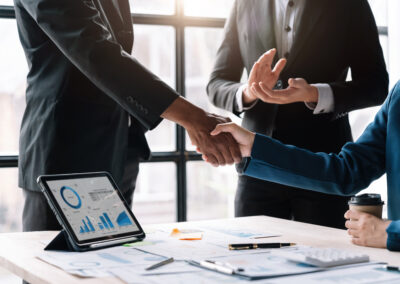 Corporate professionals shaking hands to finalize a business transaction or merger.