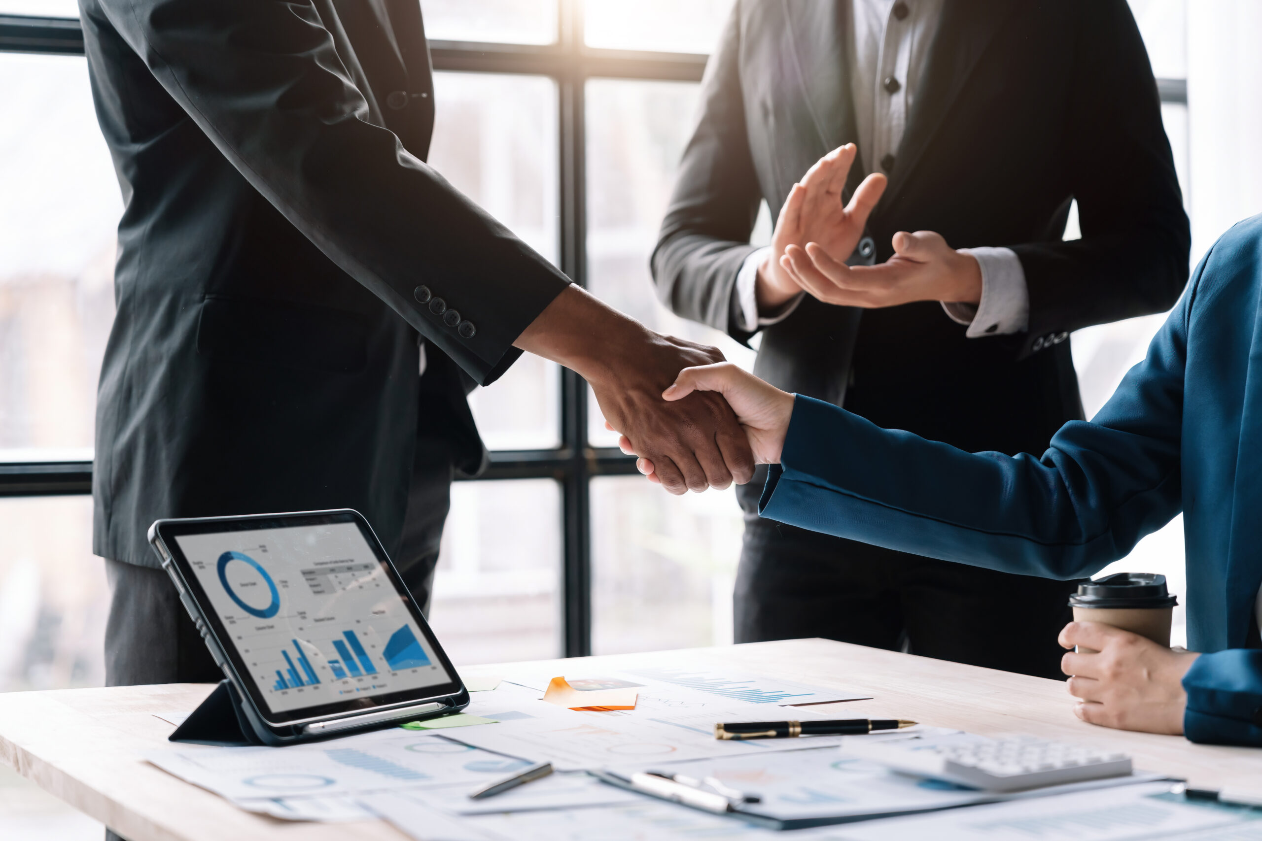 Corporate professionals shaking hands to finalize a business transaction or merger.