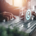 Corporate Attorney using laptop computer on desk with copyright icon background.