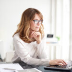 Virtual paralegal working on laptop at desk. 