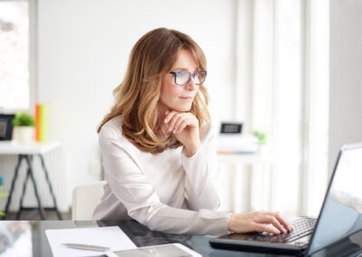 Virtual paralegal working on laptop at desk.