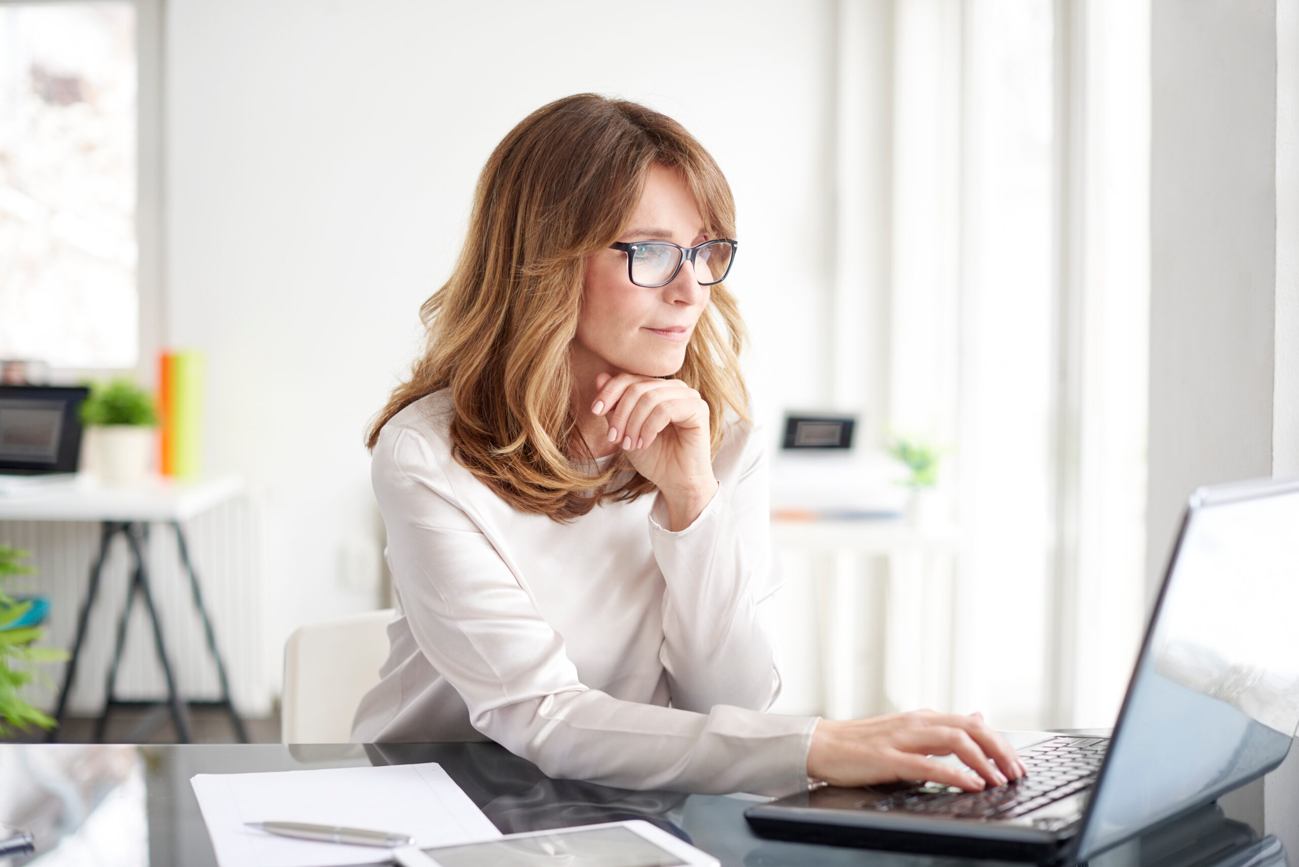 Virtual paralegal working on laptop at desk. 