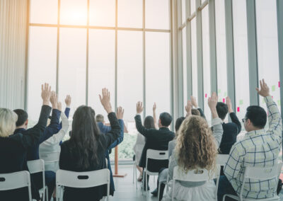 Group of business people raise hands up to agree,people raising hands during seminar,Audience voting in professional education surrounding.