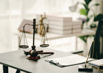 law firm courtroom Law books, computer and scales of justice on table in lawyer office